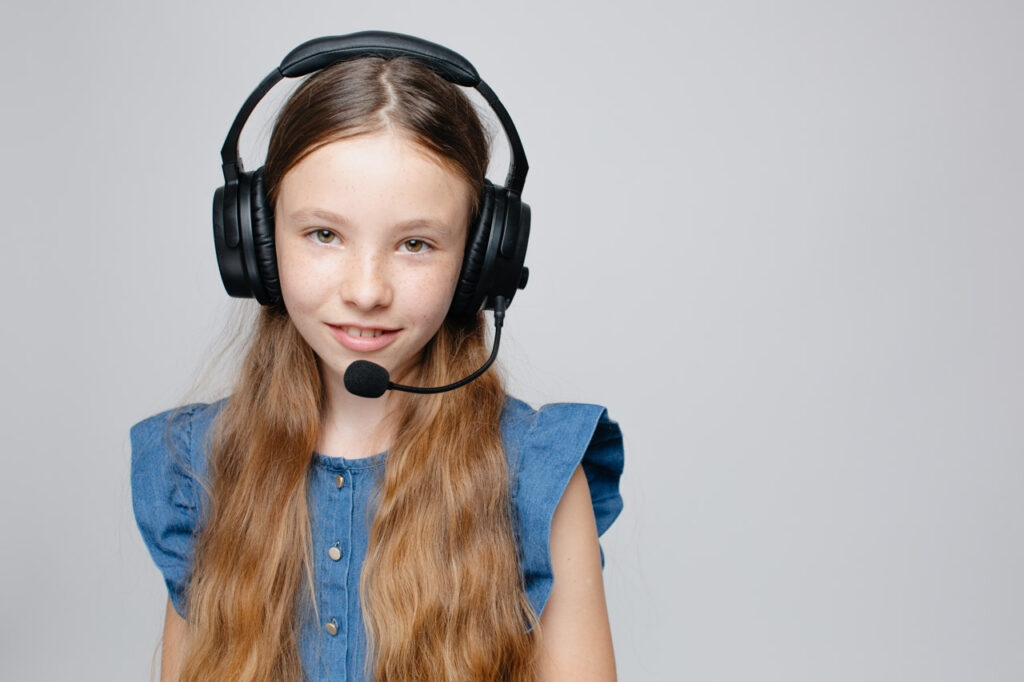 dziewczynka ze słuchawkami z mikrofonem na głowie
