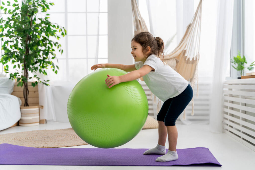 dziewczynka z dużą zieloną piłką